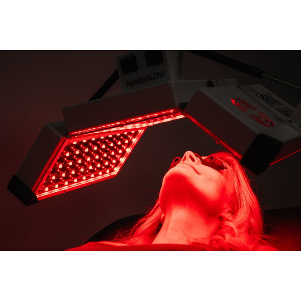 Person receiving red light therapy under a device labeled 'ApolloGLOW'.