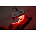 Person receiving red light therapy under a device with a dark background