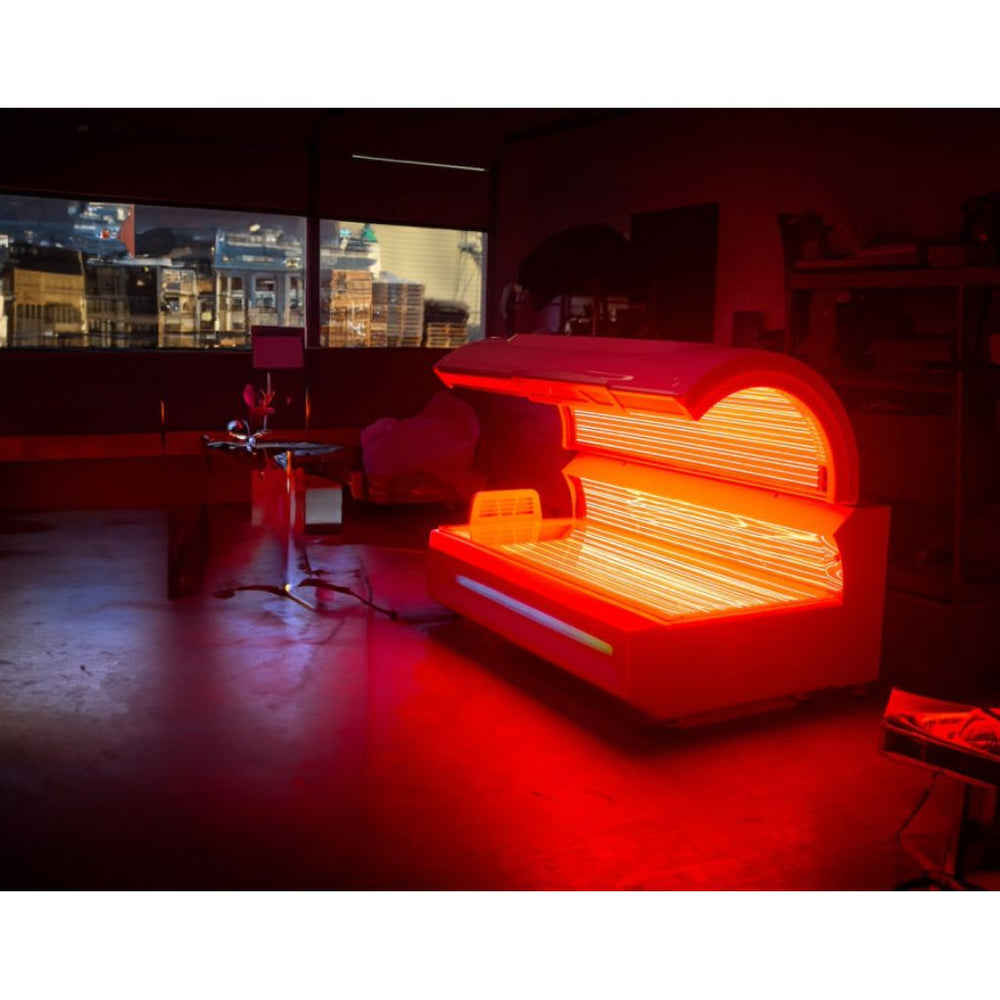 Eros Red Light Therapy bed in a dimly lit room