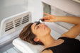 Woman about to begin her red light therapy treatment on the Eros bed