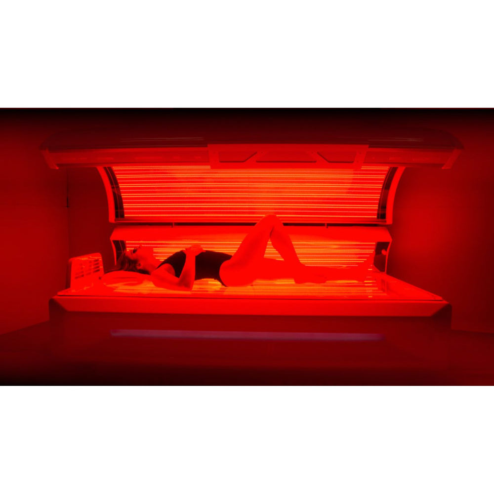 Woman lying inside a red light therapy bed