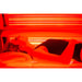 Person lying inside a red light therapy bed with glowing red lights.
