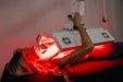 Person receiving red light therapy treatment using a panel.