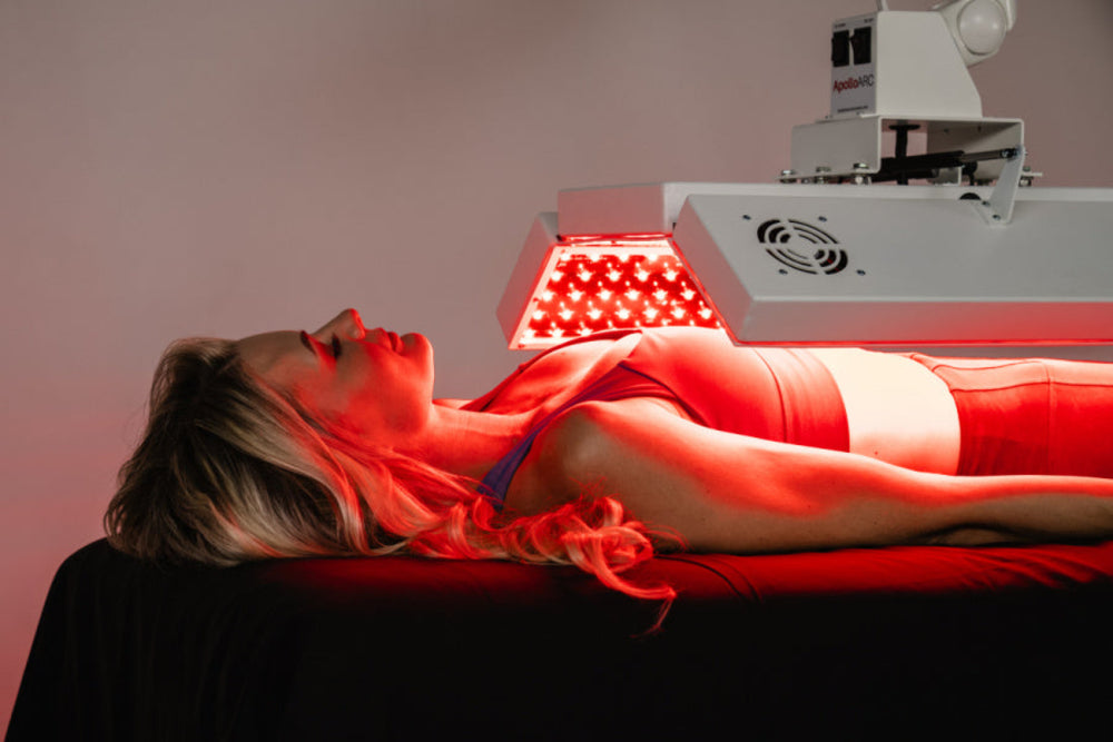 Person receiving red light therapy treatment with a machine.