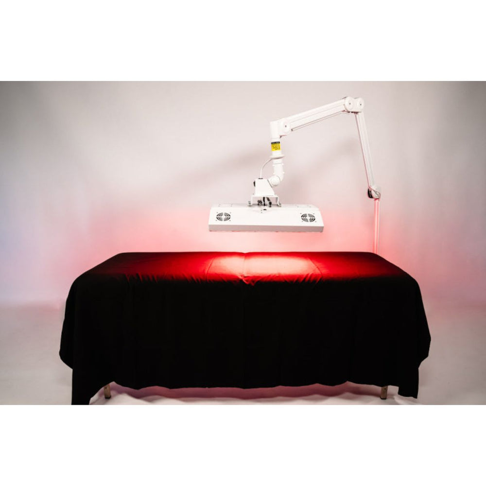 Red light therapy device on a black table with a white background