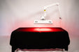 Red light therapy device on a black table with a white background