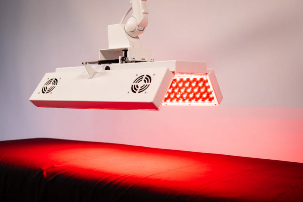 Red light therapy device emitting a red glow on a neutral background