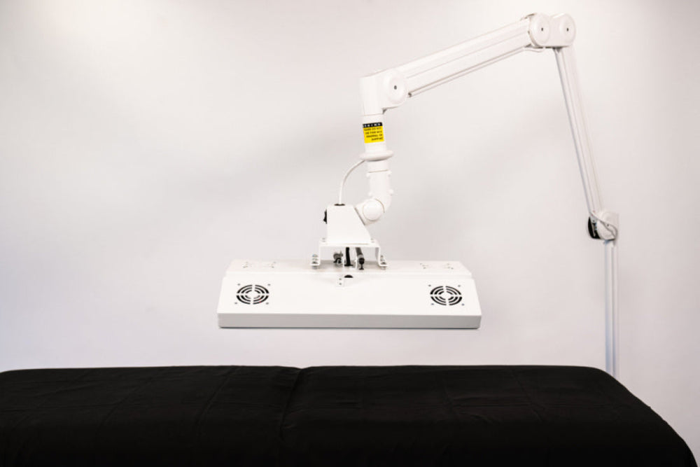 White lamp with adjustable arm on a black surface against a white background