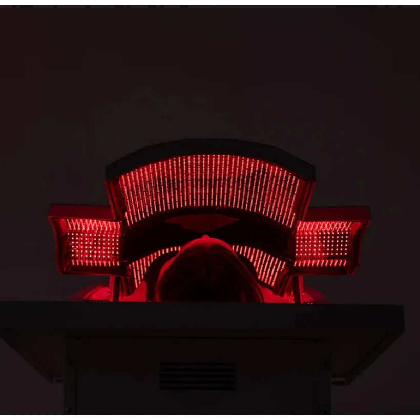 Person sitting in a red light therapy chair with a dark background