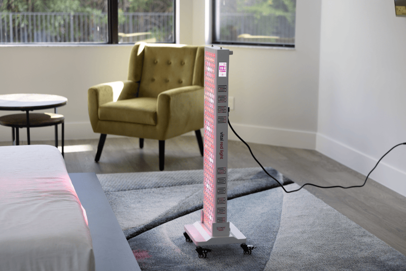 Tall rectangular object with pink and white design on a gray carpeted floor in a room with a yellow armchair and table.