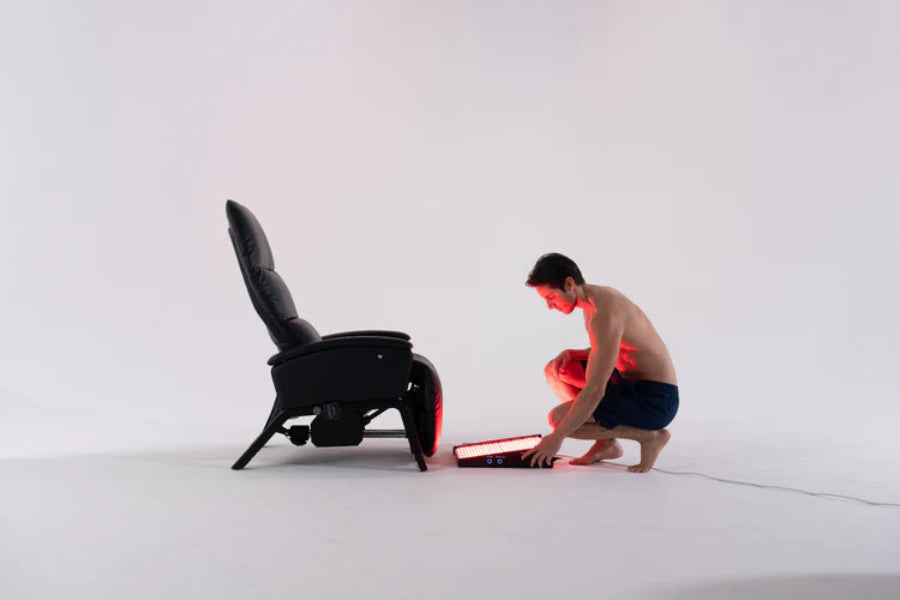 Person assembling a foot red light therapy device on a white background