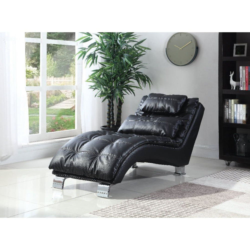 Black leather recliner chair in a room with a large window, plant, and bookshelf.