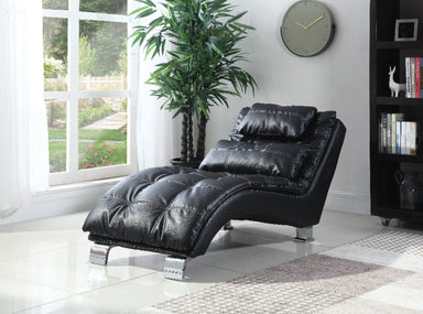 Black leather recliner chair in a room with a large window, plant, and bookshelf.