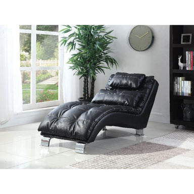 Black leather recliner chair in a room with a large window, plant, and bookshelf.