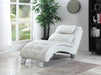 White chaise lounge chair in a room with a large window, plant, and bookshelf.