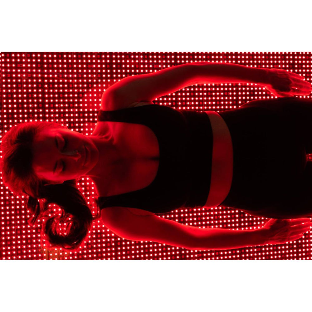 Person lying on a red LED floor with a blurred background