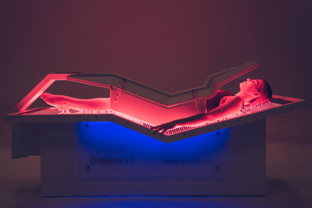 Person lying on a medical device with red and blue lighting