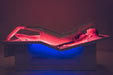 Person lying on a medical device with red and blue lighting