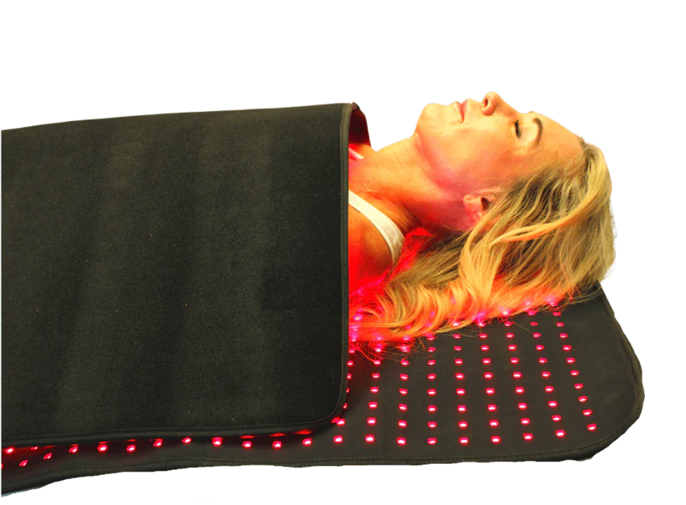 Person lying on a black mat with red LED lights on a white background