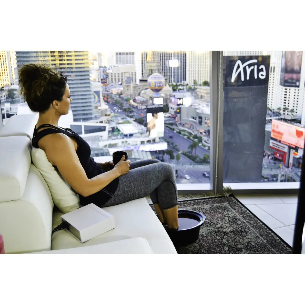 Woman sitting on a couch with a view of the Las Vegas Strip from a high-rise.