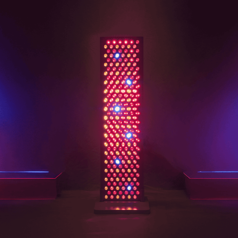 Tall vertical red light therapy fixture with multicolored LEDs on a dark background