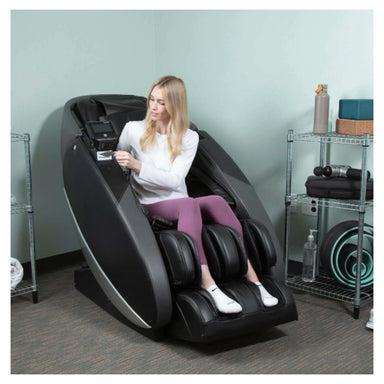 Woman using a massage chair in a room with shelves in the background